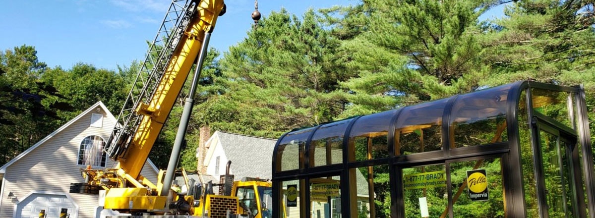 Crane lifting roof trusses on wood frame house construction
